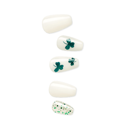 imPRESS nails in coffin shapes, featuring shiny white polish with varying green shamrock designs