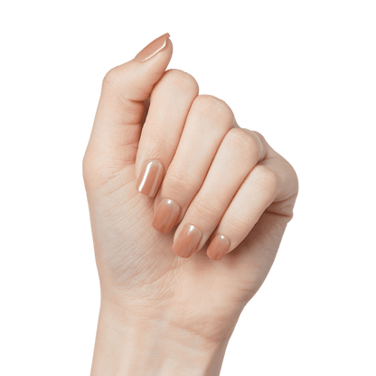 A hand modeling a press-on manicure in short, squoval shape in nude color with mirror effect. Nails are imPRESS Color FX in &
