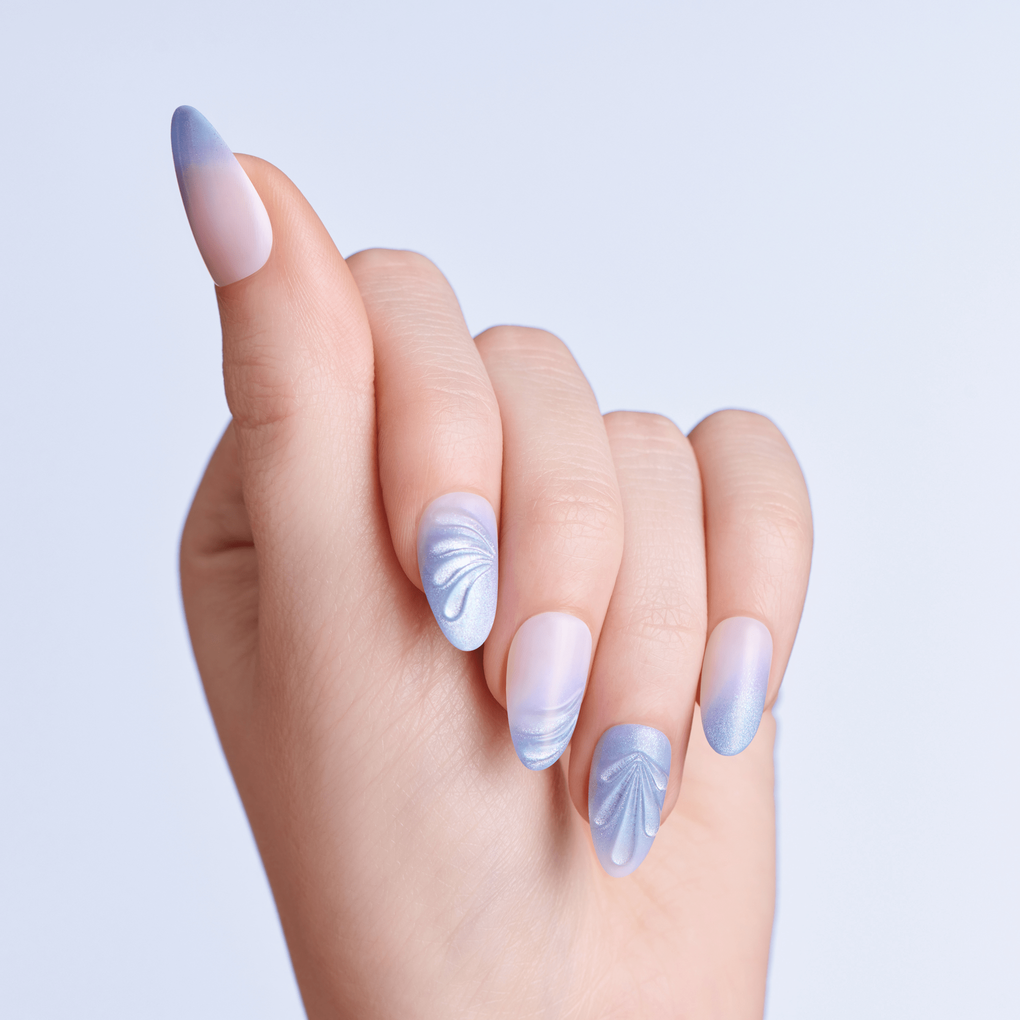 Hand with pastel nail art on a light purple background