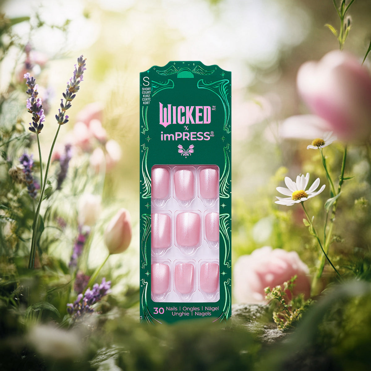 Wicked x imPRESS press-on nails in pink with green packaging surrounded by flowers.