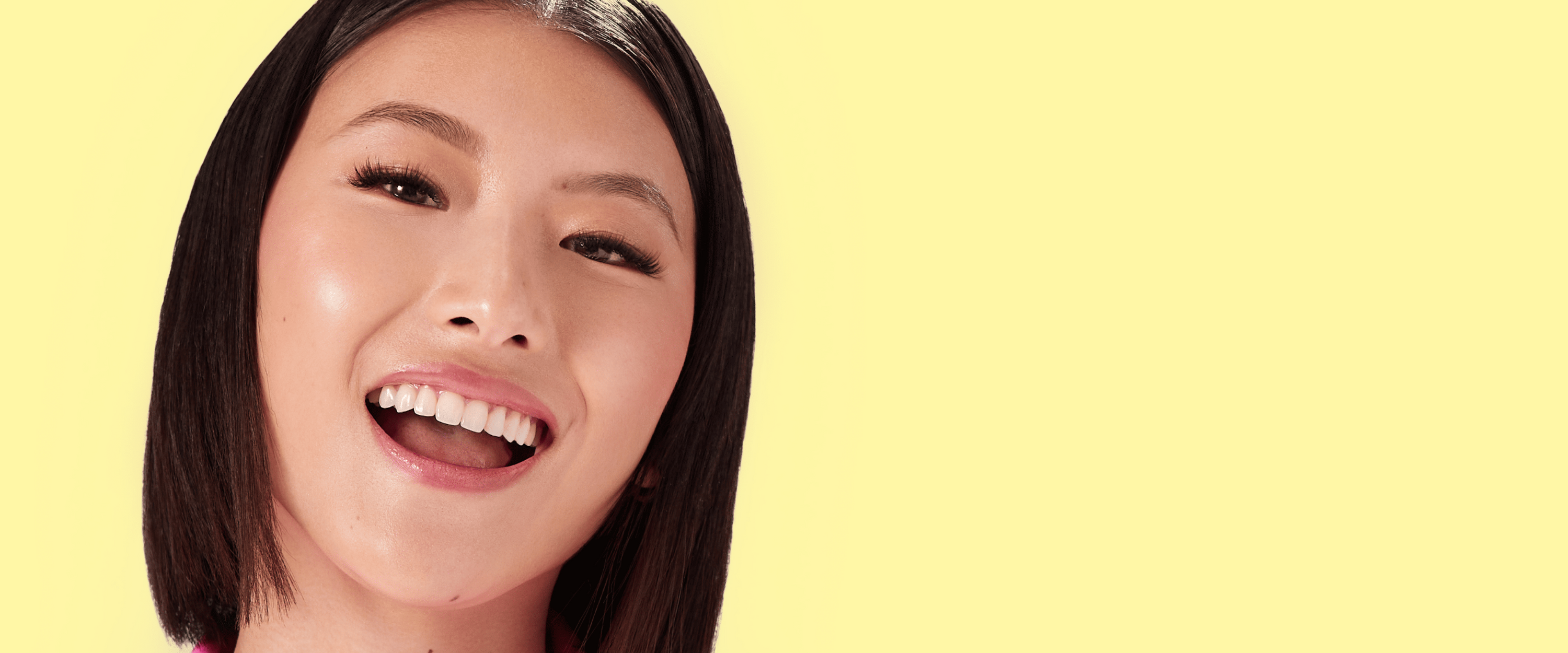 A woman with almond-shaped eyes modeling false lashes from imPRESS. Lashes are full, curly and add depth to her eyes. 