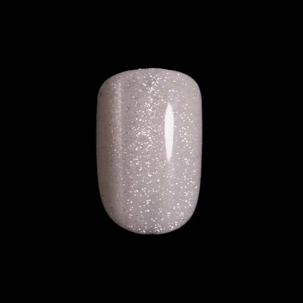 Close-up, moving image of a single, sparkly, white, press-on nail in short, squoval shape. Nail is from imPRESS ColorFX in &