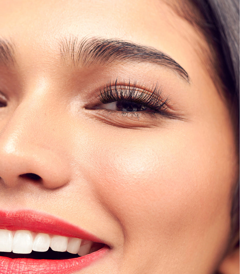 Close-up of woman's face with red lipstick and black false lashes.