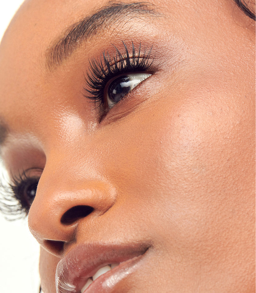 Close-up of woman's face showing full lashes and natural makeup look.