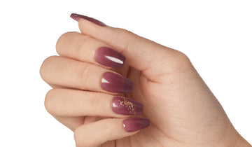 Hand model showcasing a set of imPRESS Manicure red press on nails. Nail color is a deep burgundy color.