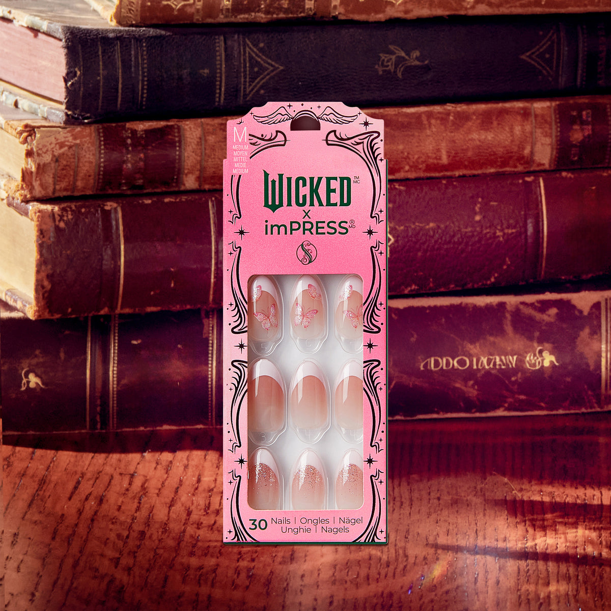 Wicked x imPRESS press-on nails package displayed against vintage books.