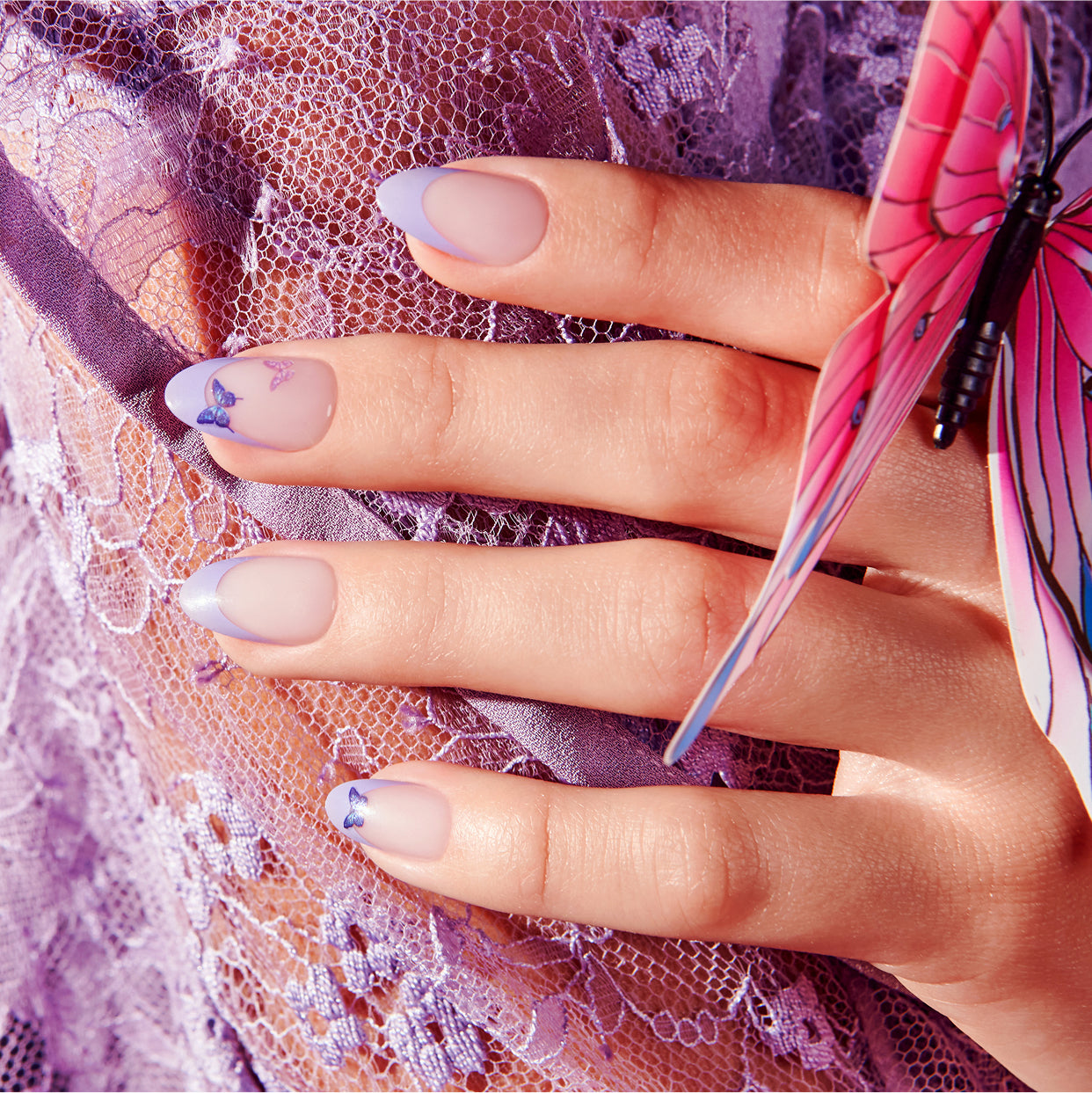 Manicured nails with purple butterfly designs on lace background