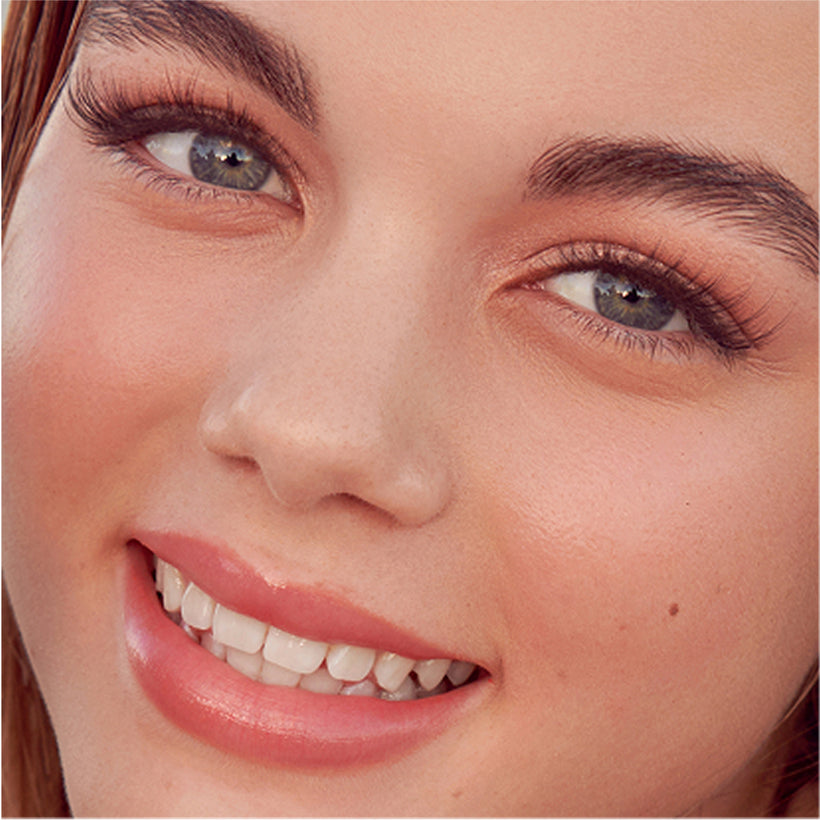 Woman wearing imPRESS Demi-Edgy press-on nails, smiling at camera
