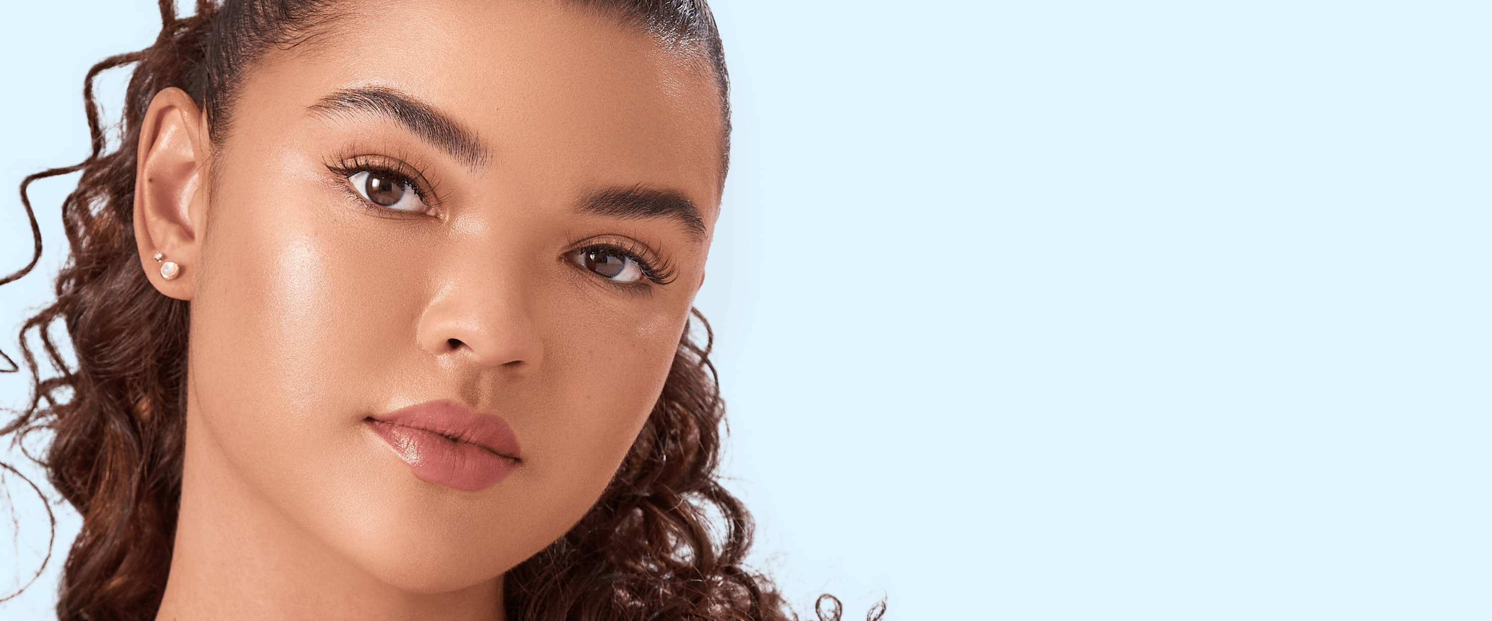 A young woman wearing false lashes from imPRESS that look natural with a light, wispy nature. 